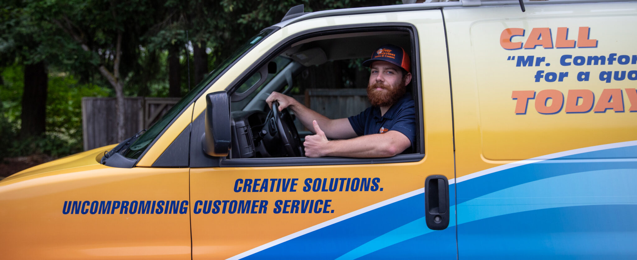 Heating & cooling technician driving a company truck.