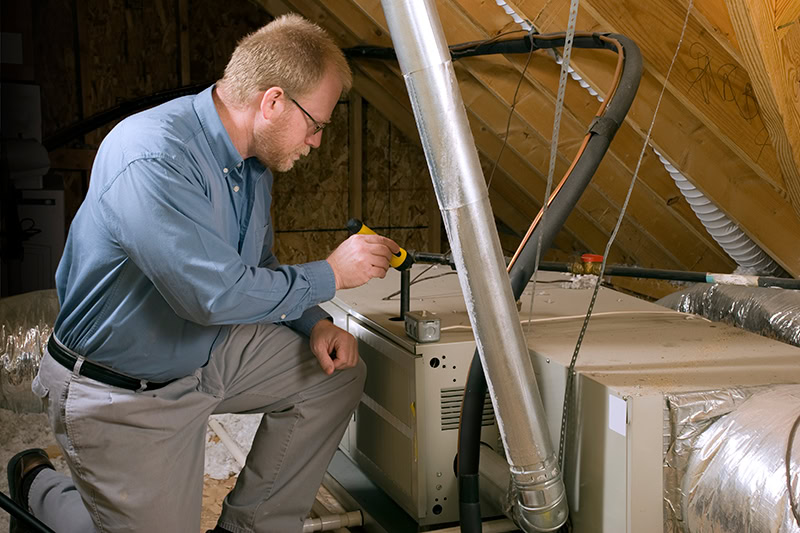 7 Furnace Maintenance Tips. Handy man working on a furnace.