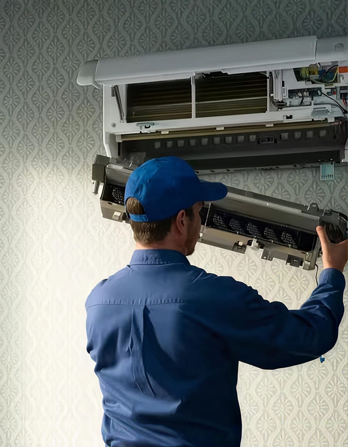 HVAC technician working on ductless AC unit.