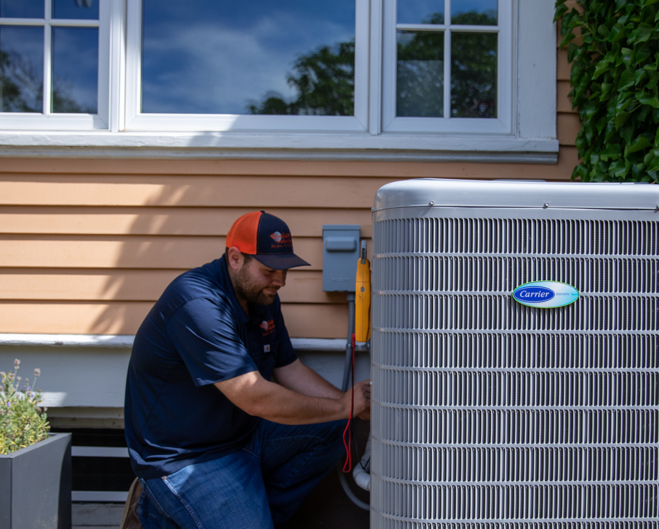 Comfort Solutions technician servicing an outdoor air conditioning condenser unit