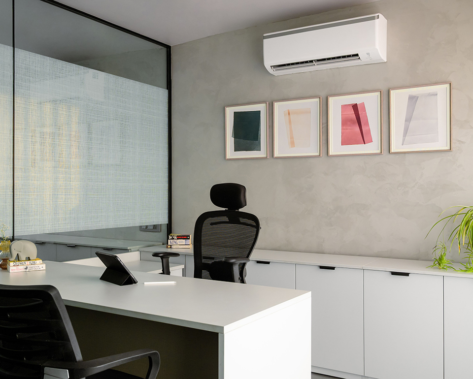 Ductless mini-split unit mounted above a modern office workspace