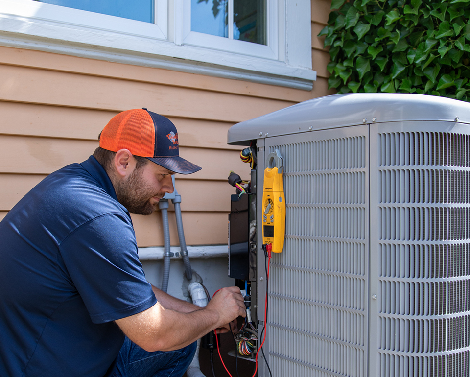 Comfort Solutions technician testing the electrical panel of an outdoor AC unit